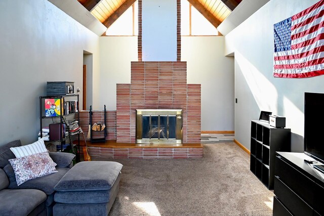 carpeted living room with high vaulted ceiling, a glass covered fireplace, and wooden ceiling