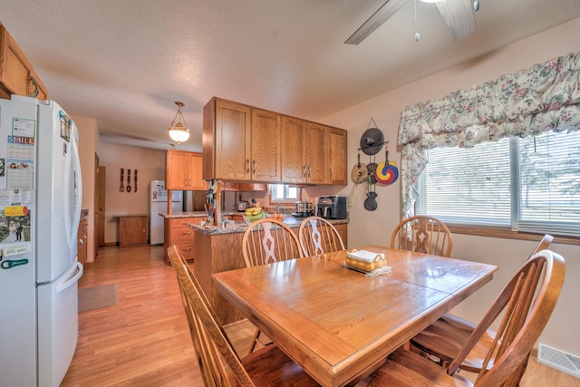 dining area with ceiling fan, visible vents, plenty of natural light, and light wood-type flooring