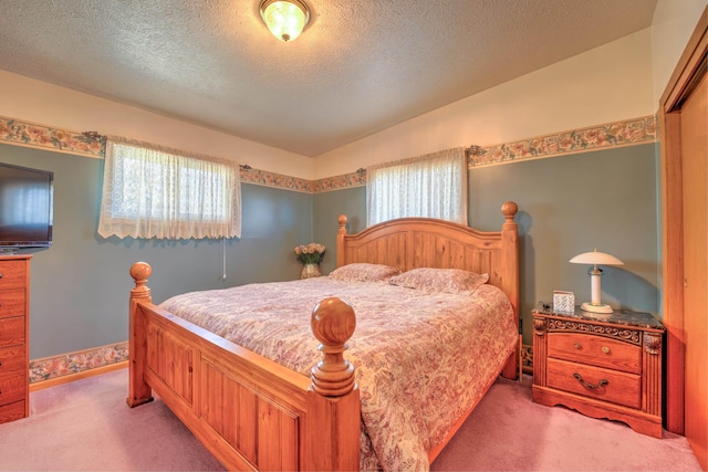 bedroom with a textured ceiling, multiple windows, and light carpet