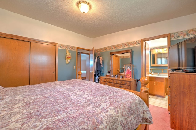 bedroom featuring carpet floors, a textured ceiling, a sink, and connected bathroom