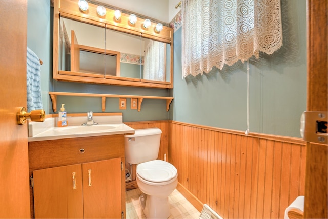bathroom with vanity, wood walls, a wainscoted wall, and toilet
