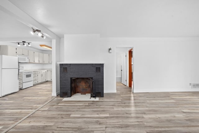 unfurnished living room featuring light wood finished floors, a fireplace, and visible vents
