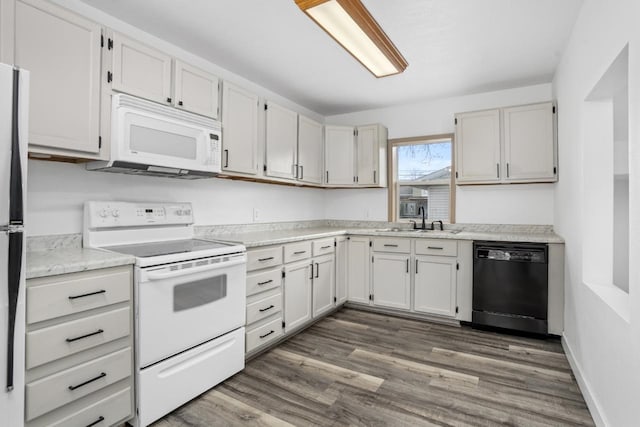 kitchen with dark wood-style flooring, white appliances, light countertops, and a sink