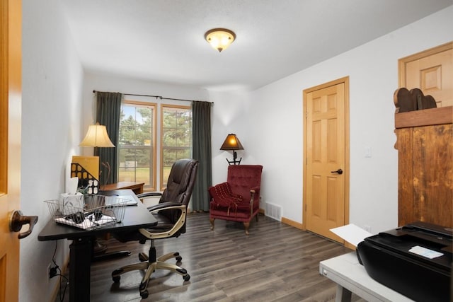 office featuring baseboards, visible vents, and wood finished floors