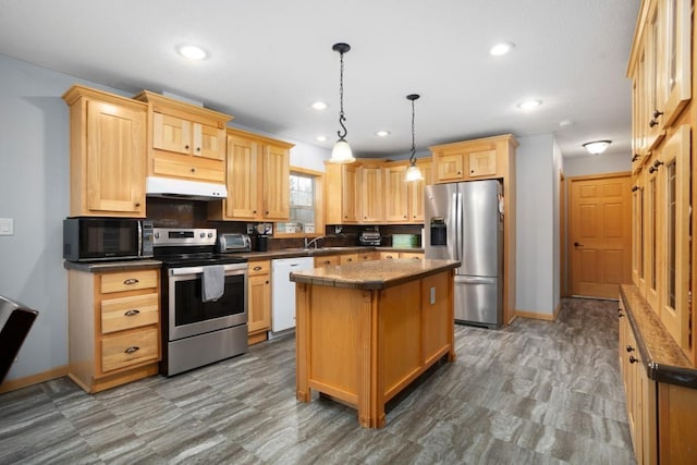 kitchen featuring baseboards, stainless steel appliances, light brown cabinetry, and under cabinet range hood
