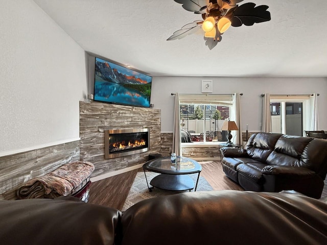 4005 Crossing St, Minot, ND 58701 - living area with ceiling fan, a textured ceiling, a stone fireplace, and wood finished floors