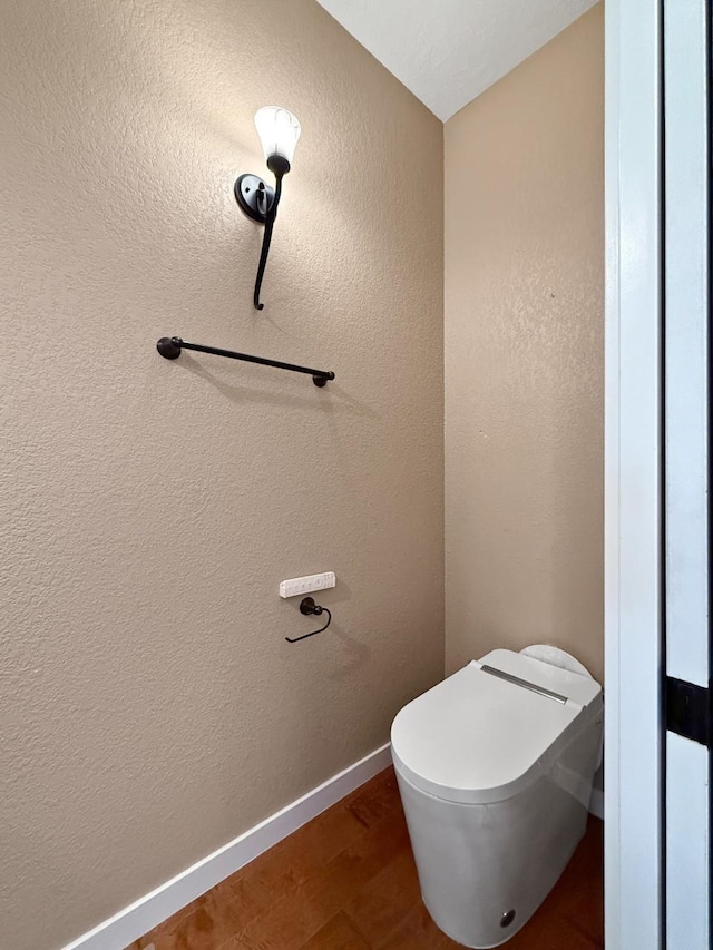 4005 Crossing St, Minot, ND 58701 - bathroom featuring toilet, baseboards, and wood finished floors