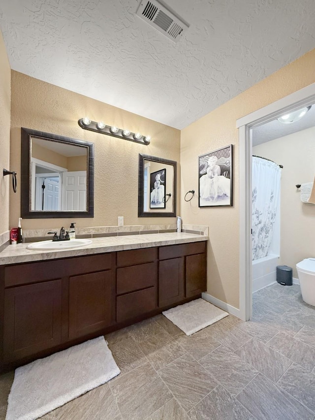 4005 Crossing St, Minot, ND 58701 - full bathroom featuring double vanity, a textured ceiling, visible vents, and a sink