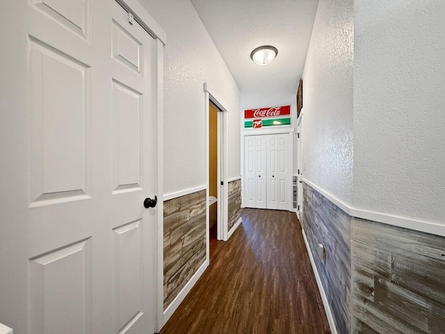 4005 Crossing St, Minot, ND 58701 - hall featuring wainscoting, dark wood-style flooring, a textured ceiling, and a textured wall