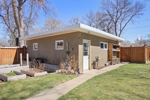 724 3rd Ave, Minot, ND 58703 - view of home's exterior featuring a gate, fence, stucco siding, and a garden