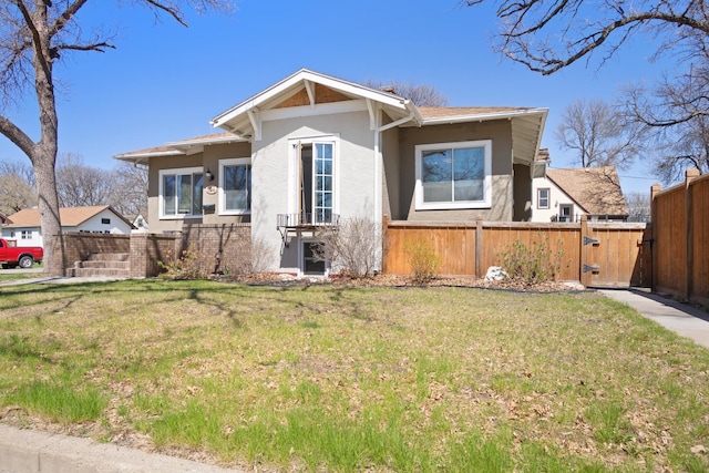 724 3rd Ave, Minot, ND 58703 - view of front of property with a gate, fence, stucco siding, and a front yard