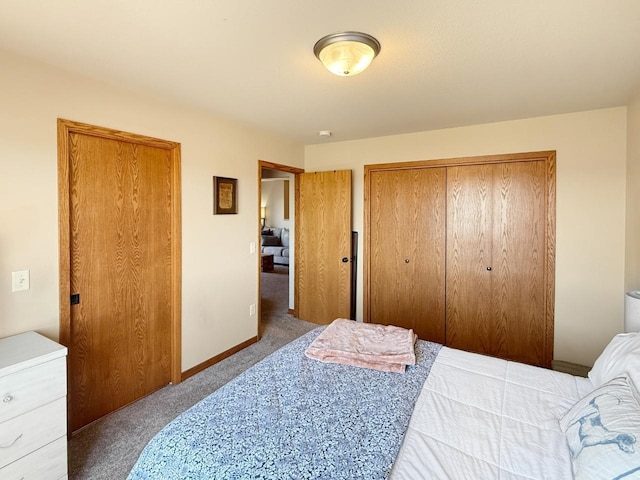carpeted bedroom with a closet and baseboards
