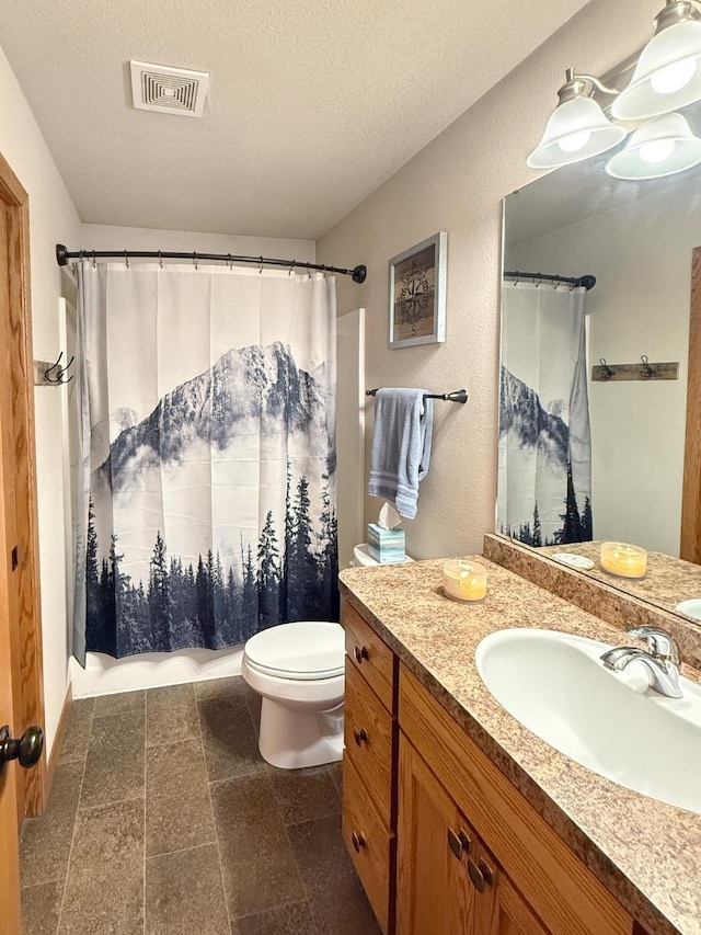 bathroom featuring toilet, vanity, curtained shower, a textured ceiling, and visible vents