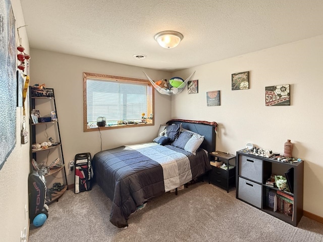 carpeted bedroom featuring a textured ceiling and visible vents