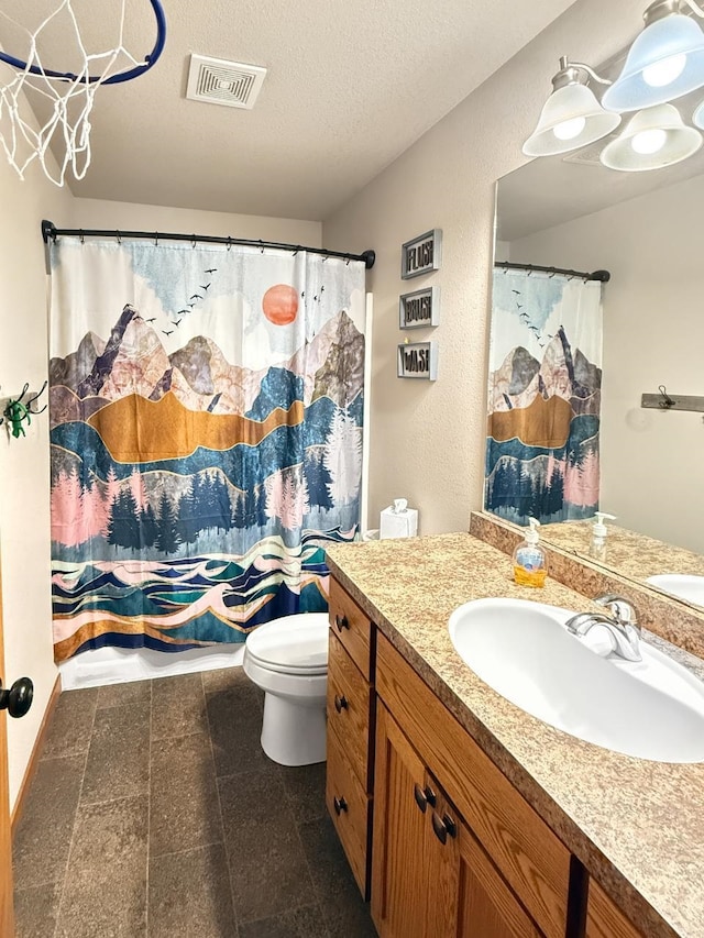 bathroom featuring toilet, curtained shower, visible vents, a textured ceiling, and vanity