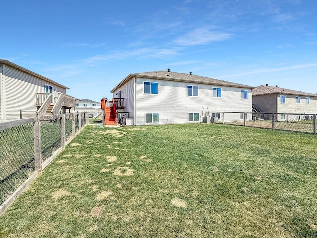 rear view of house featuring stairway, a fenced backyard, and a lawn
