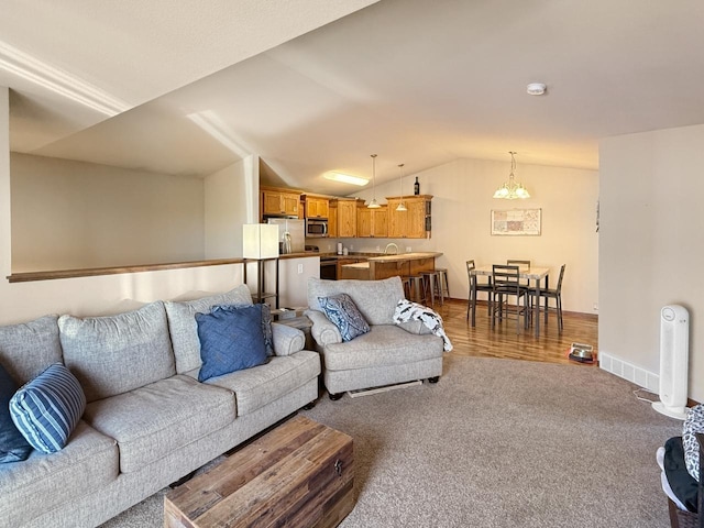 carpeted living area featuring vaulted ceiling and baseboards