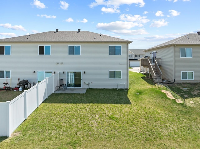 back of property featuring a yard, a patio, a fenced backyard, and stairs