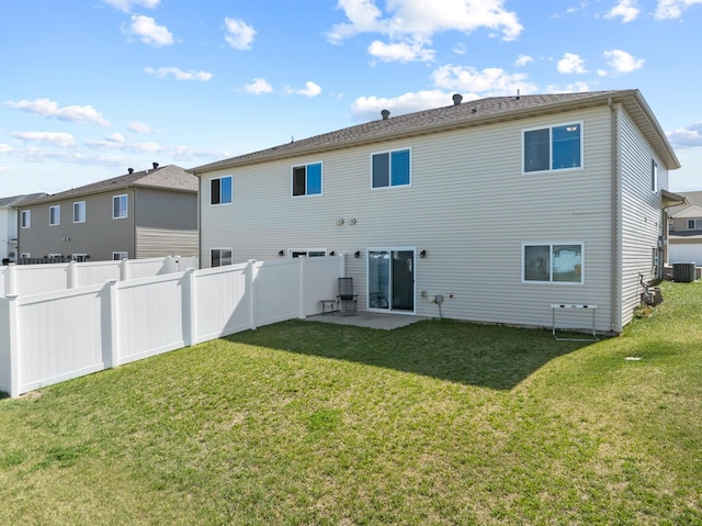rear view of property with a yard, fence, a patio, and central AC