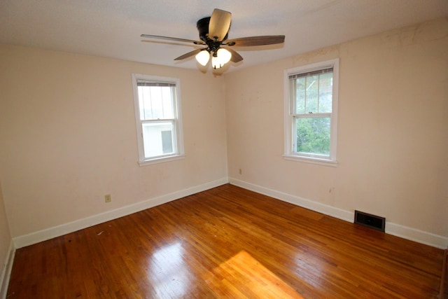 unfurnished room with a wealth of natural light, wood finished floors, baseboards, and ceiling fan