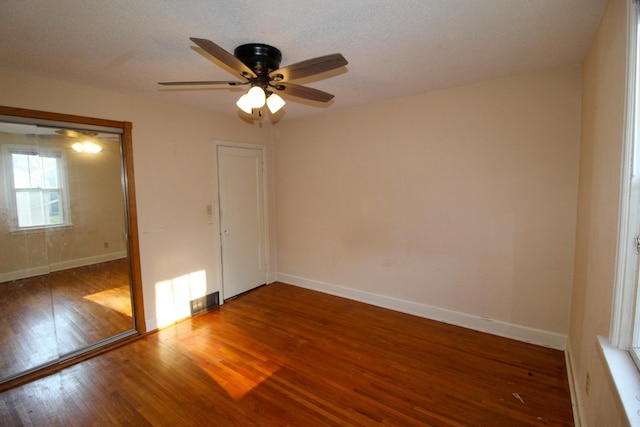 unfurnished bedroom with baseboards, a closet, a ceiling fan, and wood finished floors
