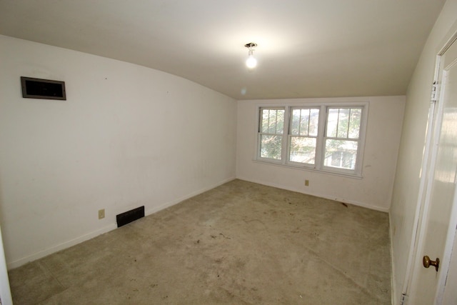 carpeted empty room with baseboards and lofted ceiling