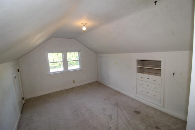 bonus room featuring vaulted ceiling, light carpet, and baseboards