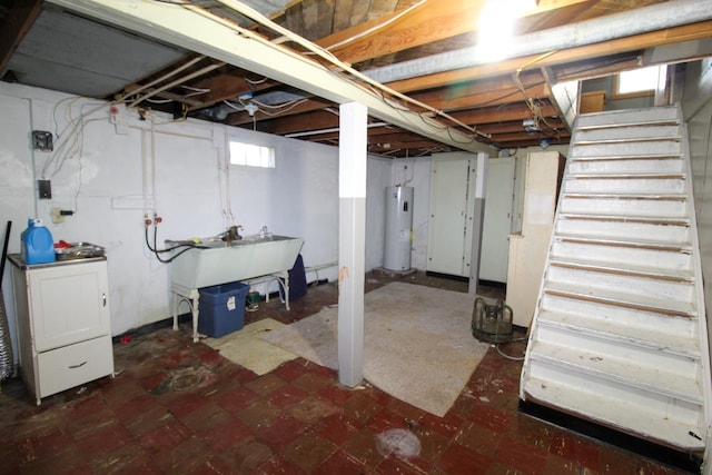 below grade area featuring a sink, water heater, stairs, and tile patterned floors