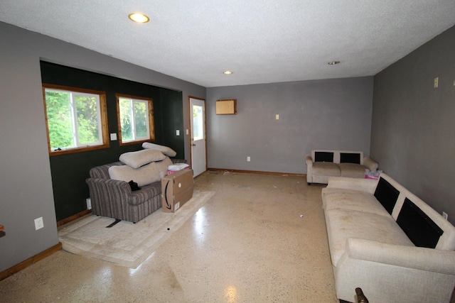 living area featuring speckled floor, baseboards, and recessed lighting