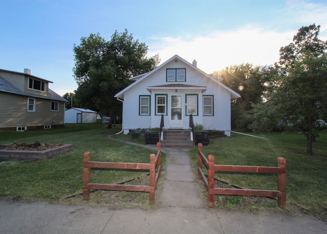 bungalow-style house featuring fence, an outbuilding, and a front yard