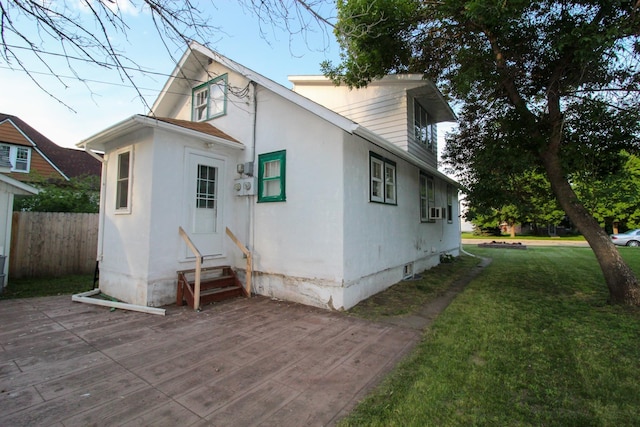 back of property with a lawn, entry steps, and fence