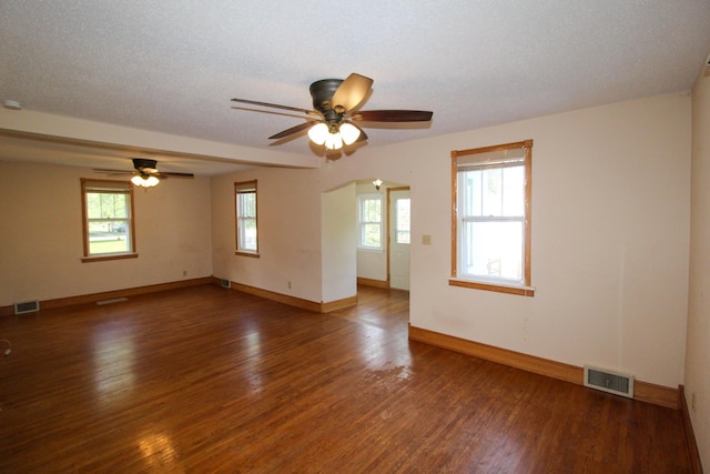 empty room with ceiling fan, baseboards, visible vents, and wood finished floors