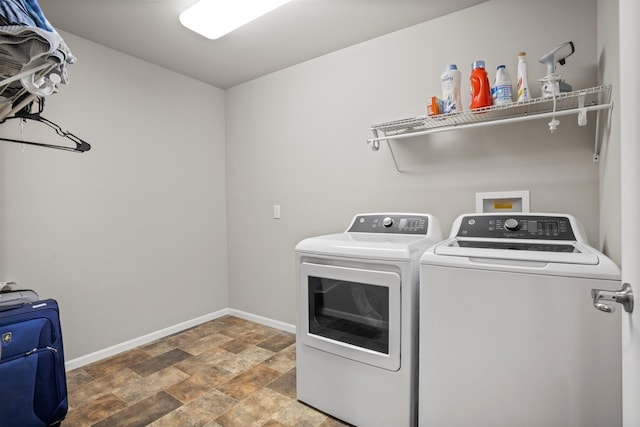 2344 NW 14th St, Minot, ND 58703 - washroom with stone finish flooring, baseboards, washing machine and dryer, and laundry area