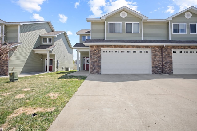 2344 NW 14th St, Minot, ND 58703 - view of property with concrete driveway, roof with shingles, an attached garage, and a front yard