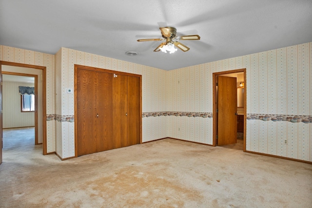 600 SW 24th Ave, Minot, ND 58701 - unfurnished bedroom featuring carpet, a closet, a ceiling fan, and wallpapered walls
