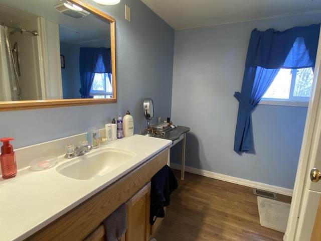 1601 72nd St, Minot, ND 58701 - full bathroom featuring wood finished floors, vanity, baseboards, and a shower with curtain