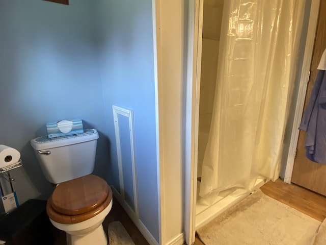 1601 72nd St, Minot, ND 58701 - bathroom with toilet, a shower stall, and wood finished floors