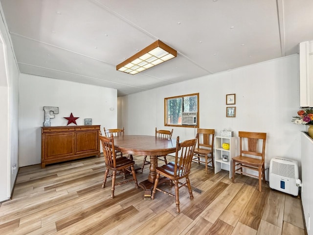 dining space with light wood-type flooring and cooling unit