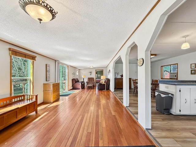 hallway featuring light wood-type flooring and a textured ceiling