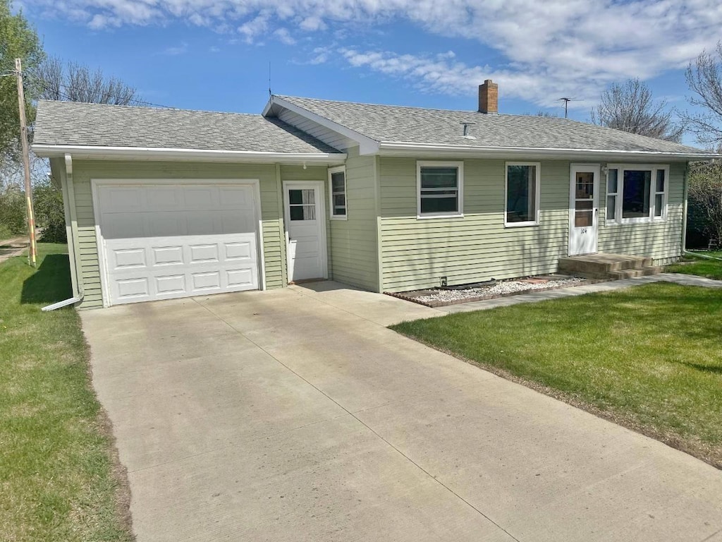 single story home featuring driveway, a chimney, a garage, and a front lawn