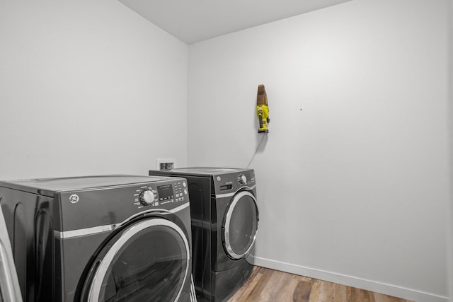 114 Mulberry Loop, Minot, ND 58703 - laundry room with washing machine and clothes dryer, baseboards, and wood finished floors