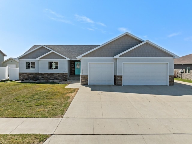 1504 Valley Bluffs Dr, Minot, ND 58701 - craftsman-style home with stone siding, a garage, driveway, and a front yard
