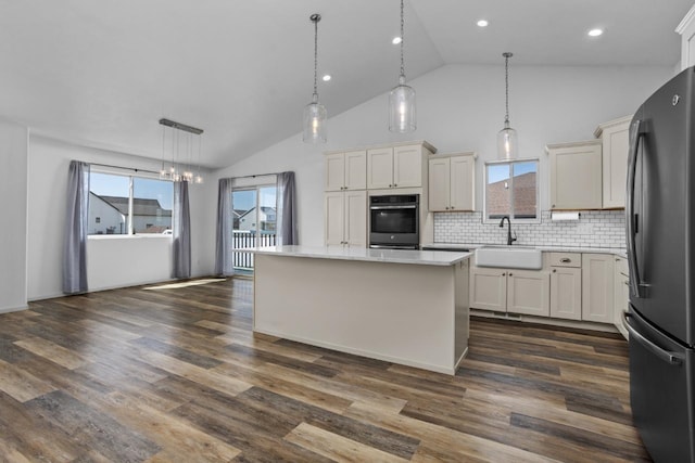 1504 Valley Bluffs Dr, Minot, ND 58701 - kitchen with freestanding refrigerator, oven, a sink, light countertops, and decorative backsplash