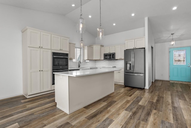 1504 Valley Bluffs Dr, Minot, ND 58701 - kitchen featuring black appliances, vaulted ceiling, backsplash, healthy amount of natural light, and a kitchen island