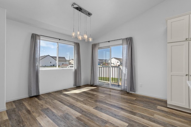 1504 Valley Bluffs Dr, Minot, ND 58701 - unfurnished dining area featuring wood finished floors, healthy amount of natural light, and vaulted ceiling