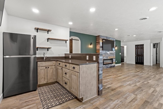 1504 Valley Bluffs Dr, Minot, ND 58701 - kitchen featuring freestanding refrigerator, a sink, dark countertops, open floor plan, and a peninsula