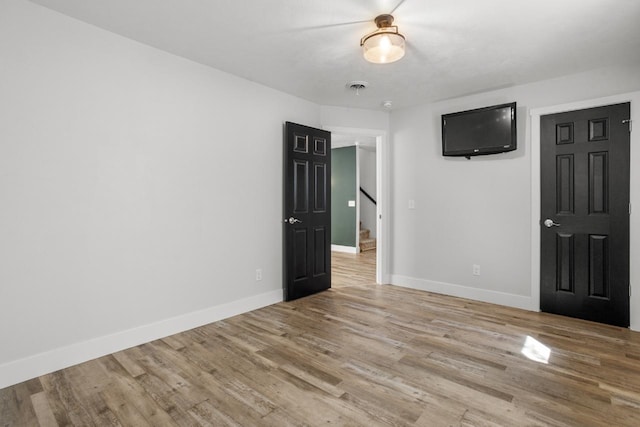 1504 Valley Bluffs Dr, Minot, ND 58701 - unfurnished room featuring light wood finished floors, baseboards, and stairway