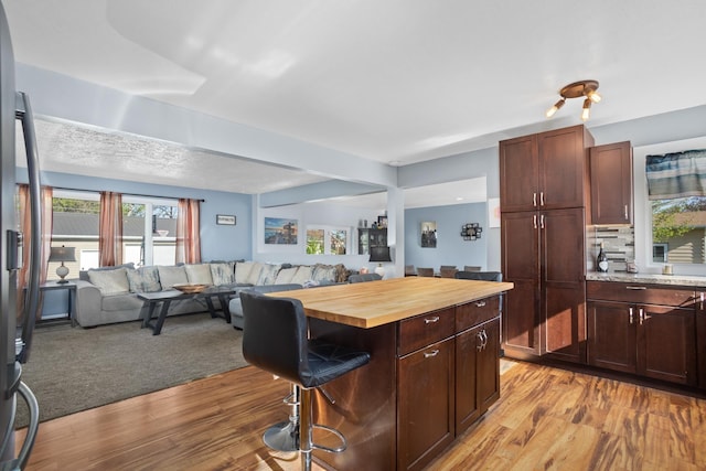 1722 1st St, Minot, ND 58701 - kitchen featuring open floor plan, wooden counters, a breakfast bar area, light wood-type flooring, and a center island