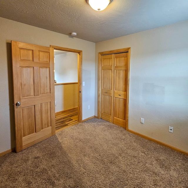 611 16th St, Minot, ND 58701 - unfurnished bedroom with carpet floors, a closet, baseboards, and a textured ceiling