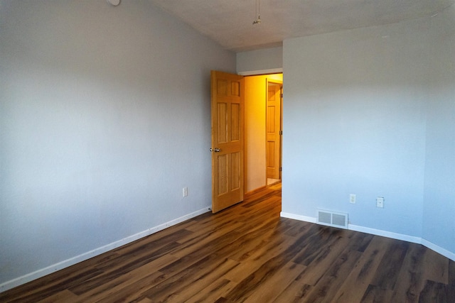 611 16th St, Minot, ND 58701 - spare room with dark wood-style floors and baseboards